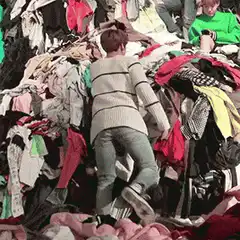 Man falls backward into a pile of clothes