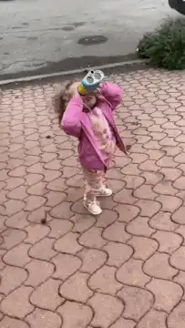Toddler balancing toilet paper on head
