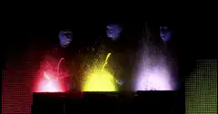 DJ trio performing with colored smoke