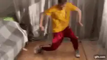 Man in yellow shirt and red pants dancing