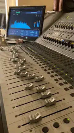 Audio mixing console with faders and monitor