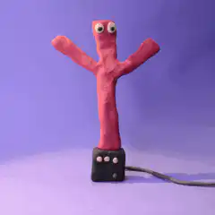 Red clay figure dancing on a plug