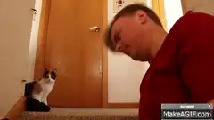 Man and cat making faces at each other