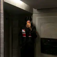 person taking mirror selfie in dark jacket