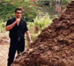 man eating dirt from a pile