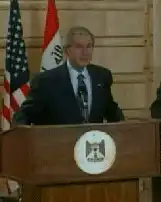 George W Bush sneezes at podium