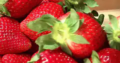 Zoom out from strawberries to fruit stand