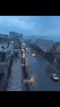 Streetlight explodes on rainy street