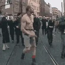 shirtless man dancing in street