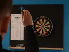 Man throws dart at board