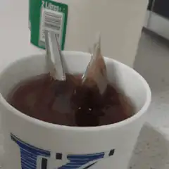 Tea bag being dipped in a cup