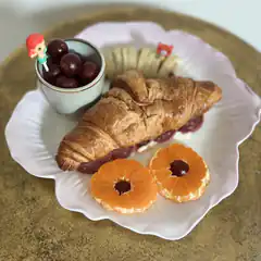 croissant sandwich with fruit and grapes
