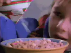 Boy pouring milk into cereal