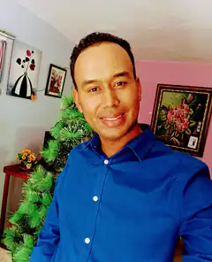 Man in blue shirt smiling indoors