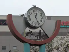 Clock with fishing silhouette sculpture