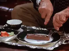 man cutting a chocolate bar with a knife and fork