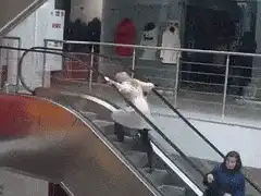 Woman sliding down escalator handrail