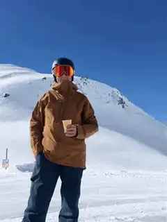 skier holding cup on snowy mountain