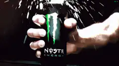 Hand holding Monster Energy can with sparks