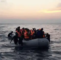 Crowded inflatable boat arriving at shore