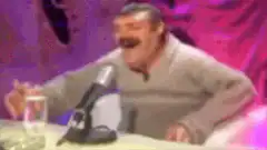 Man laughing hysterically at a table