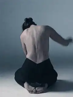 Man kneeling and slapping his back