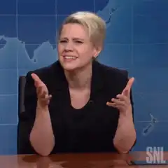 Kate McKinnon shrugging and laughing