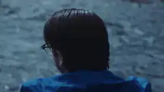 Person in blue jacket looking at water
