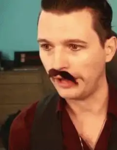 Man touches his mustache