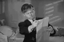 Man reading paper and smiling