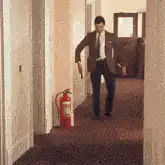 Man in suit dancing in hallway