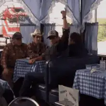cowboy raises fist in tent