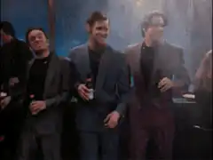 Three men in suits dancing at a party
