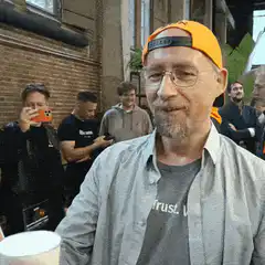 Man raises beer glass in toast