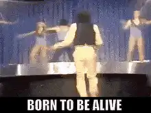 Man dancing on stage with backup dancers