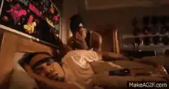 Man shaking sleeping man in bed