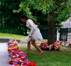 woman in white dress smelling flowers