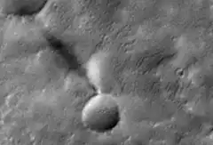 Grainy close-up of a crater on a celestial body