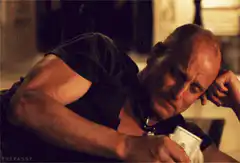 bald man rubbing money on head