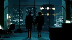 Two people holding hands in front of city skyline