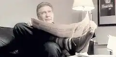 Man reading newspaper with feet up