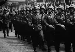 Nazi soldiers marching past Hitler