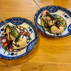 Two plates of Japanese food on wooden table