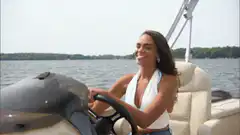 woman driving boat and waving