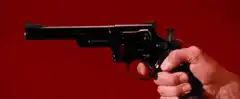 Hand holding revolver against red background