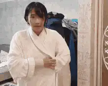 Woman opens bathrobe to reveal dress