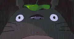 Totoro holding a leaf in the rain
