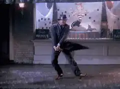 Man in fedora dancing on wet street