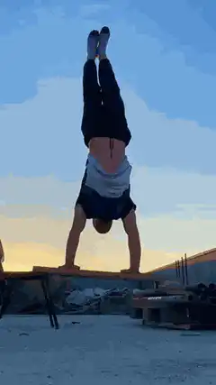 Man doing handstand pushups on a bench