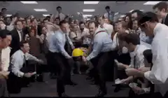 Office workers dancing around a yellow hard hat